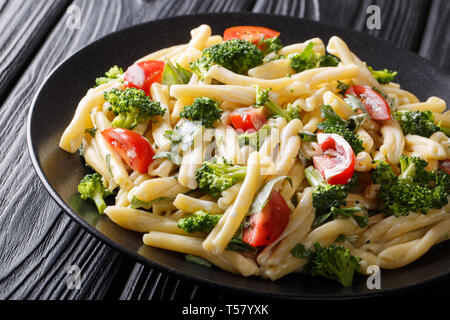 Pasta Casarecce recipe with vegetables, herbs, seasoned with creamy cheese sauce close-up on a plate on the table. horizontal Stock Photo