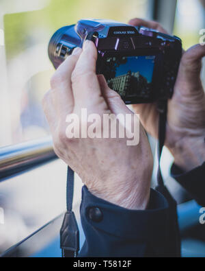 Enthusiast photographer takes a picture with his Nikon Coolpix camera. Stock Photo