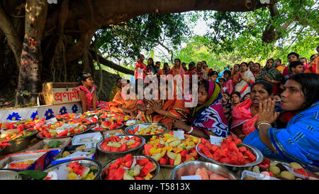 Devotees sit beside arrays of offerings placed under the ancient banyan tree, which is worshipped by local Hindus on the first day of Bengali Year. Na Stock Photo