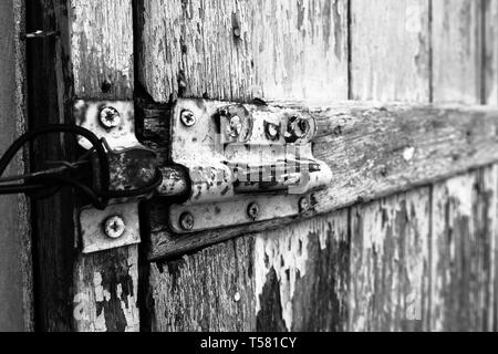Close-up of the door lock on wooden door in black and white. Stock Photo