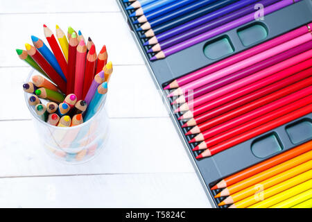 Multi colored pencils in jar on wooden table Stock Photo