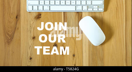 Join our team, text on wood desktop with keyboard and mouse in view Stock Photo