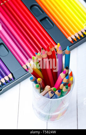 Multi colored pencils in jar on wooden table Stock Photo