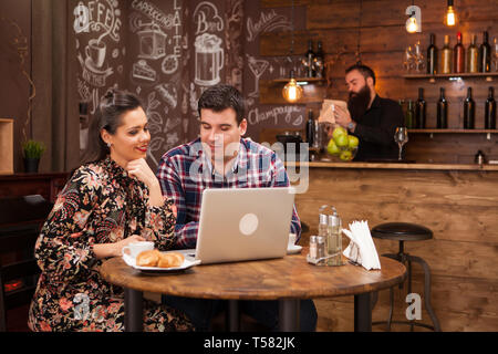 Attractive couple at a business meeting in the restaurant disucssing working moments at lunch time. Hipster pub. Stock Photo