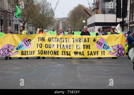 Extinction Rebellion protesters seen behind a large and wide banner during a protest in London. Stock Photo