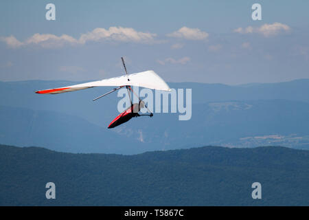 Man Hand-gliding over Mointains on a Hot Summer Day