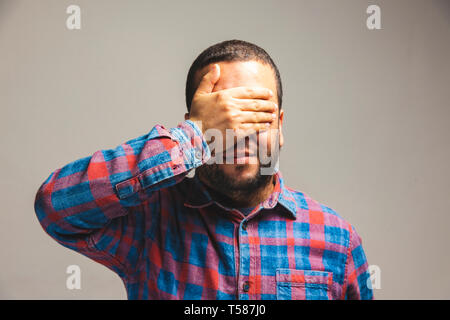 close up view of a man covering his eyes with hand Stock Photo