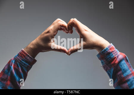Cropped Hands Making Heart Shape Against grey background Stock Photo