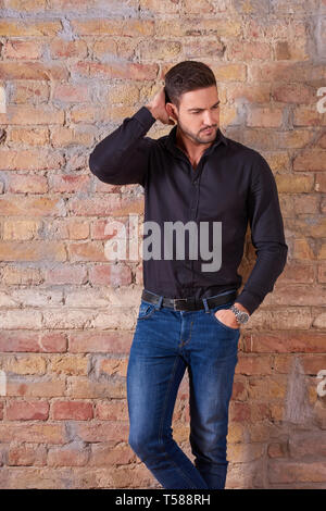 Portrait of a thinking handsome young businessman in a black shirt. Stock Photo