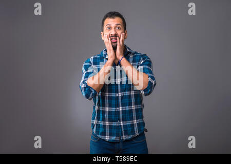 A young black man standing and feeling surprised Stock Photo