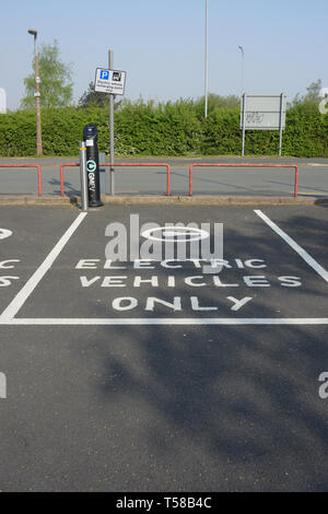 Electric vehicles only surface marking, empty parking bay and electric vehicle recharging point and pole mounted sign in Bury Lancashire uk Stock Photo