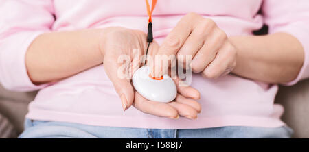 Alarm button for emergency call in senior woman hands Stock Photo