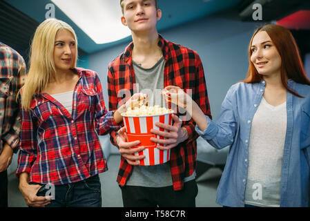 Group of friends with popcorn in cinema hall Stock Photo