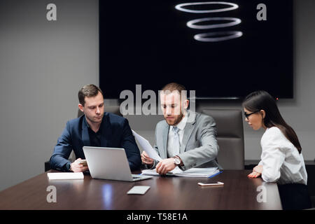 Business people working together on their laptop in a meeting room Stock Photo