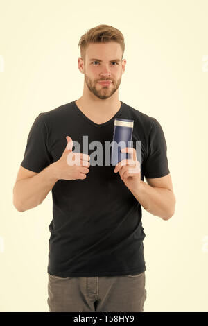 Remedies get rid of dandruff. Man hold bottle shampoo show thumb up isolated white. Itchy scalp and flakiness skin. Shampoo solve dandruff problem. Dandruff common male problem. Anti dandruff shampoo. Stock Photo