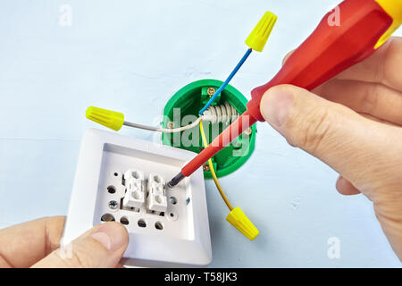 Mounting of new button for double light switch with help of screwdriver, electrical work. Stock Photo