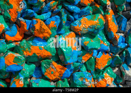 Bright abstract background on the rocks orange, blue and green paint stains Stock Photo