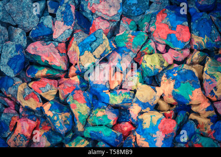 Pebbles painted colored paints in bright spots Stock Photo
