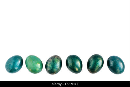 Easter eggs in different shades of turquoise and gold in a row on isolated white background. Stock Photo