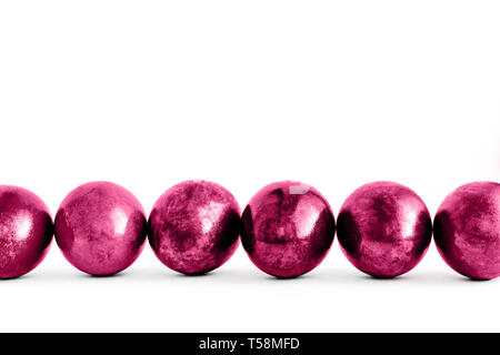 Trendy pink Easter eggs lined on white background. Close-up. Stock Photo