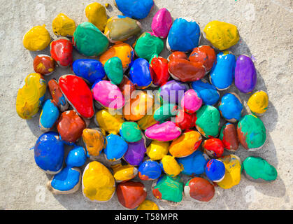 Colored stones colored paints in different colors lie on a flat surface. Close-up Stock Photo