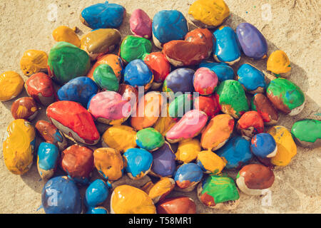 Colored stones colored paints in different colors lie on a flat surface. Close-up Stock Photo