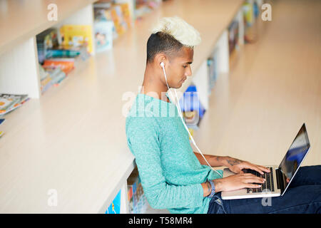 Modern guy working on article in library Stock Photo