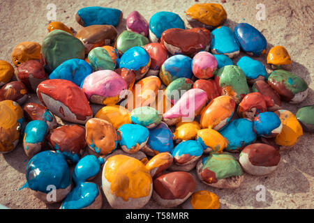 Colored stones colored paints in different colors lie on a flat surface. Close-up Stock Photo