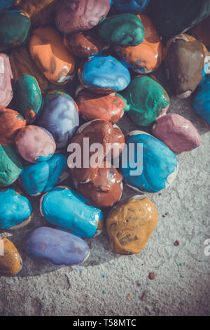 Colored stones colored paints in different colors lie on a flat surface. Close-up Stock Photo