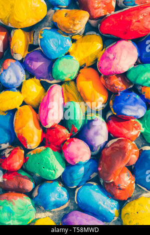 Colored stones colored paints in different colors lie on a flat surface. Close-up Stock Photo