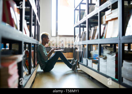 Hipster guy spending time in library Stock Photo
