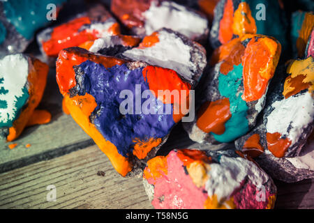 colorful paint paint spreads on the surface of small stones close-up, macro Stock Photo