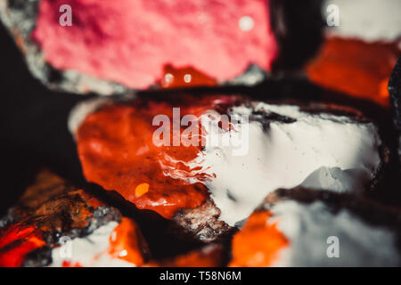 colorful paint paint spreads on the surface of small stones close-up, macro Stock Photo