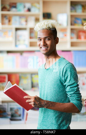 Smiling black college student reading book Stock Photo