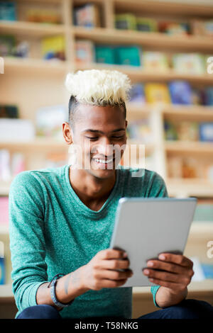 Cheerful black guy watching video on tablet Stock Photo