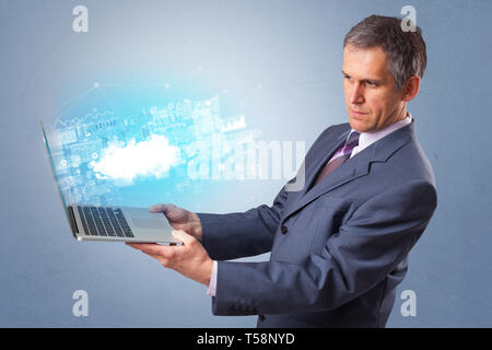 Man holding laptop projecting notifications, symbols and information based on cloud technology system  Stock Photo