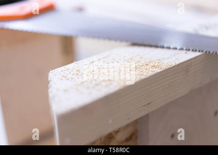 installation of pine wood flooring - environmentally friendly flooring. saw on the background of a wooden floor. Stock Photo