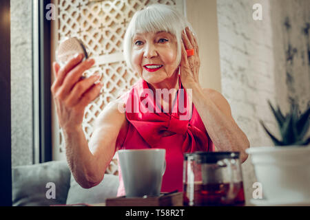 Pleasant nice aged woman touching her hair Stock Photo