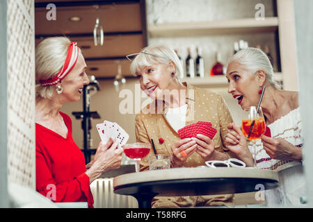 Positive happy female friends playing card games Stock Photo