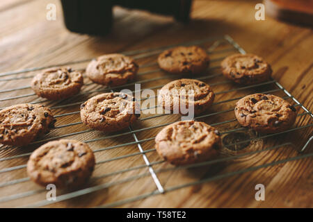 Close-up of freshly baked cookies on oven grill over wooden table with a dslr camera. Stock Photo