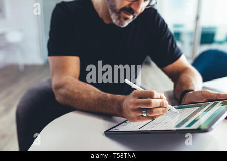 business professional working on tablet pc with a digital pen. businessman checking financial report on his digital tablet. Stock Photo