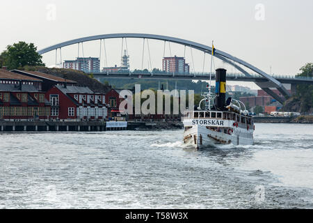 The historic SS Storskär passing Svindersviksbron and the Swedish Cruising Association (Svenska Kryssarklubben) in Nacka Strand, Stockholm Stock Photo