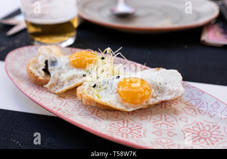 plate of fried eggs on crispy toast with truffle Stock Photo