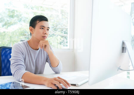 Concentrated Asian designer at work Stock Photo