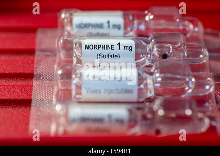 Close-up of morphine sulfate 1 mg/ml vial for injections or infusion against red background. Ideal for medical concept blogs or articles Stock Photo