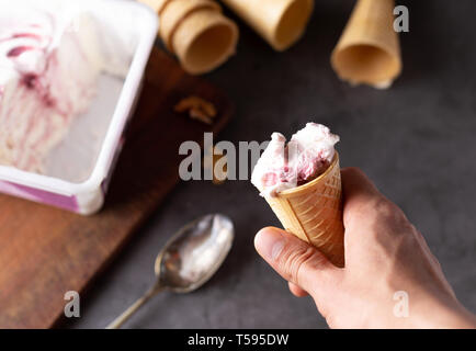 Person with Ice cream cornet in hand Stock Photo
