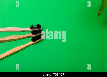 Three bamboo brushes laying on the green background with copy space Stock Photo