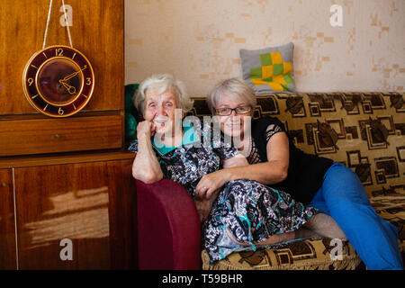 Elderly woman in home with his adult daughter posing for photos. Stock Photo