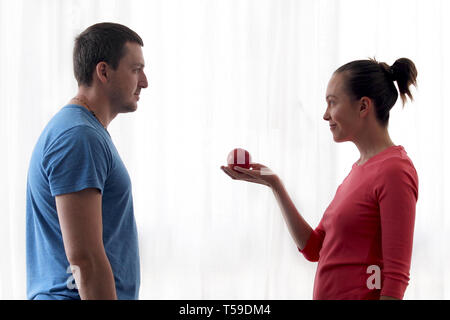 Woman gives apple to man Stock Photo