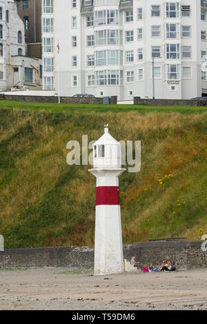 Port Erin beach with a lighthouse beacon on the sand and a hotel behind, Isle of Man, UK. Stock Photo